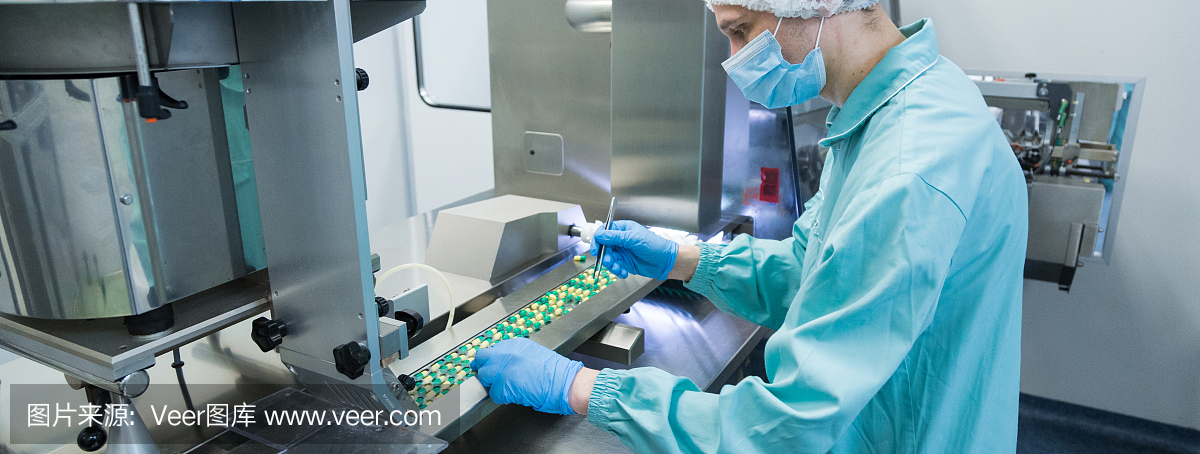 制药工业工人穿着防护服在无菌工作条件下生产药片
